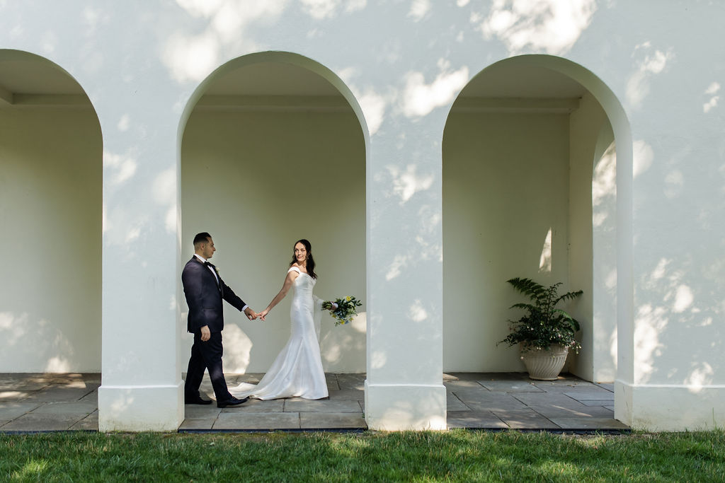 Bride and groom newly wed walking behind estate in Indianapolis.