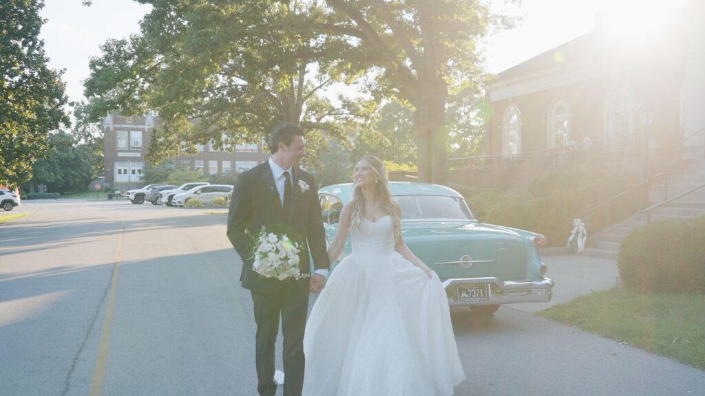 Louisville wedding video screen grab of newly wed couple walking away from antique car.