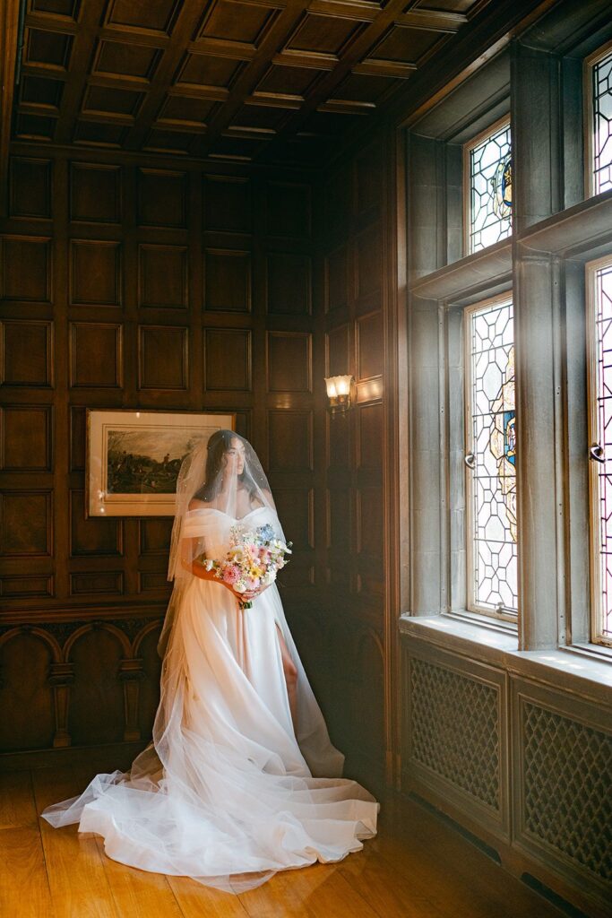 Bride standing next to window at Laurel Hall.
