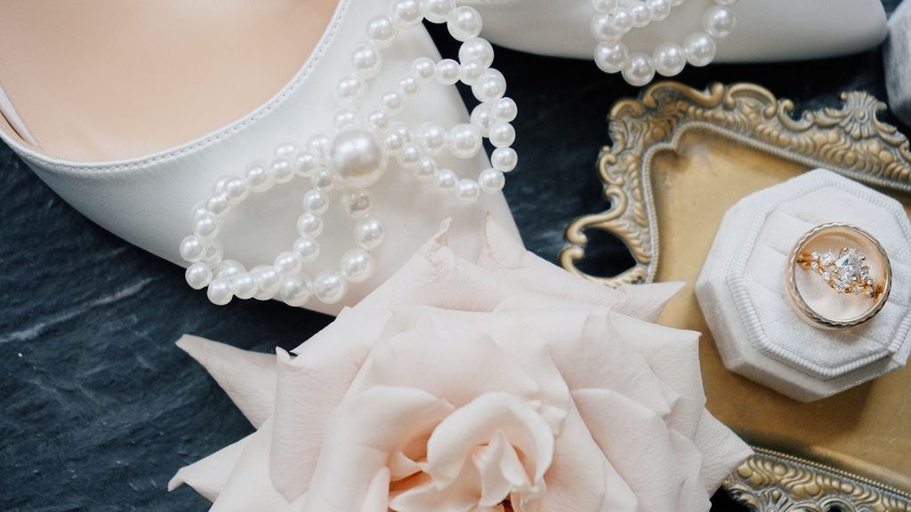 Professional Videography shot of brides wedding ring and dress heels for flat lay.